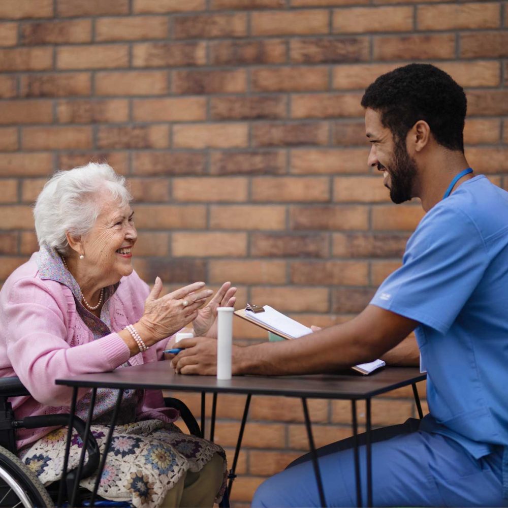 park trust caregiver explaining taking pills to senior woman